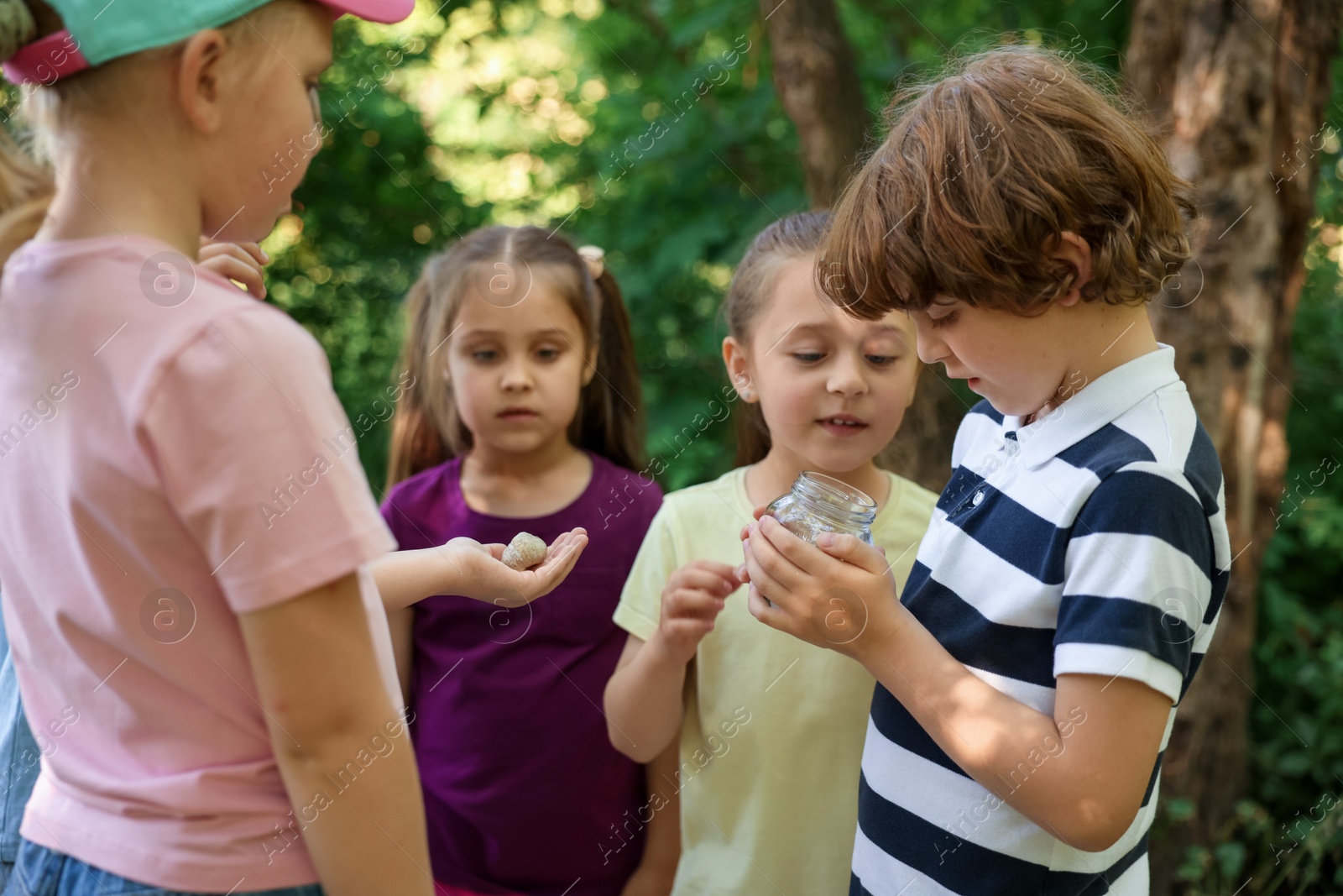 Children with snail and jar in nature Photo of Children with snail and jar in nature
