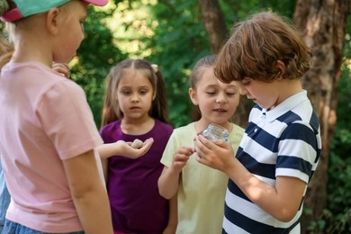 Photo of Children with snail and jar in nature