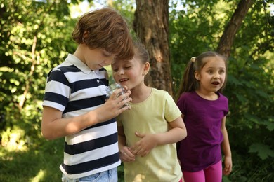 Photo of Children with jar spending time in nature