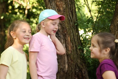 Photo of Cute little girl and her friends playing in nature