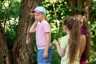 Photo of Cute little girl and her friends playing in nature