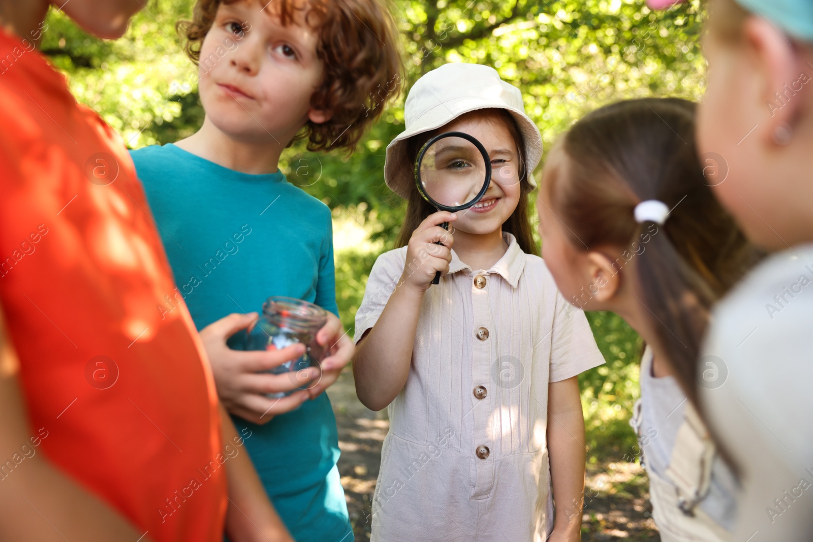 Children with magnifying glass and jar in nature Photo of Children with magnifying glass and jar in nature