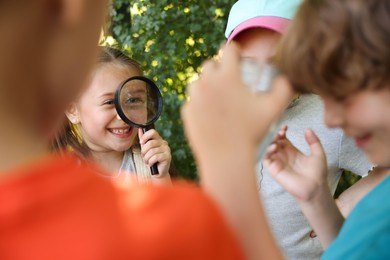 Photo of Group of children with magnifying glass in nature, selective focus