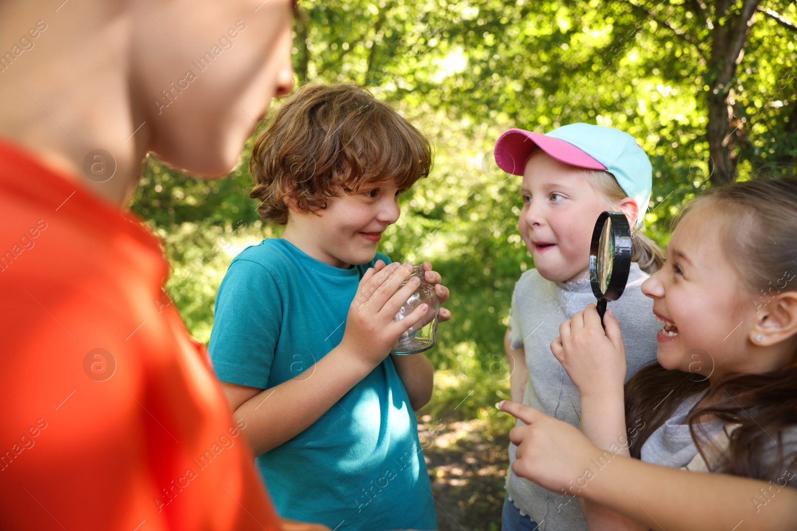 Children with magnifying glass and jar in nature Photo of Children with magnifying glass and jar in nature