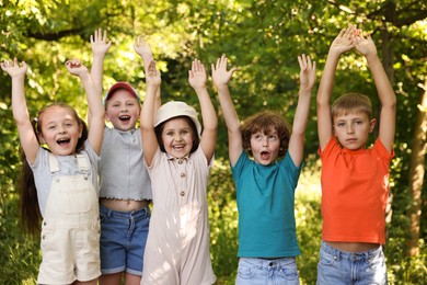 Photo of Happy children with raised hands in nature