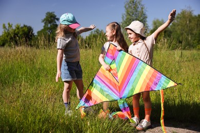 Photo of Cute little girls with colorful kite in nature