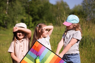 Photo of Cute little girls with colorful kite in nature