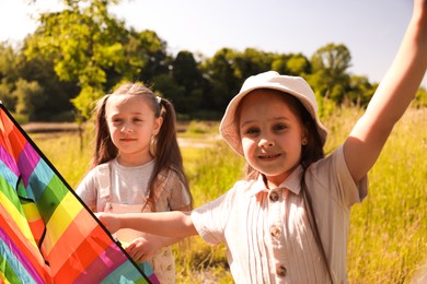 Photo of Cute little girls with colorful kite in nature