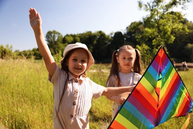 Photo of Cute little girls with colorful kite in nature