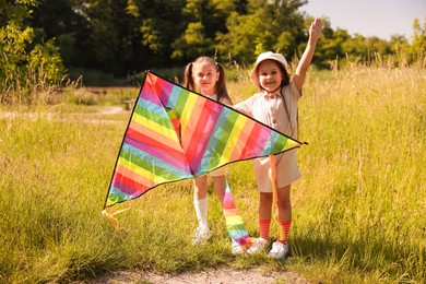 Photo of Cute little girls with colorful kite in nature