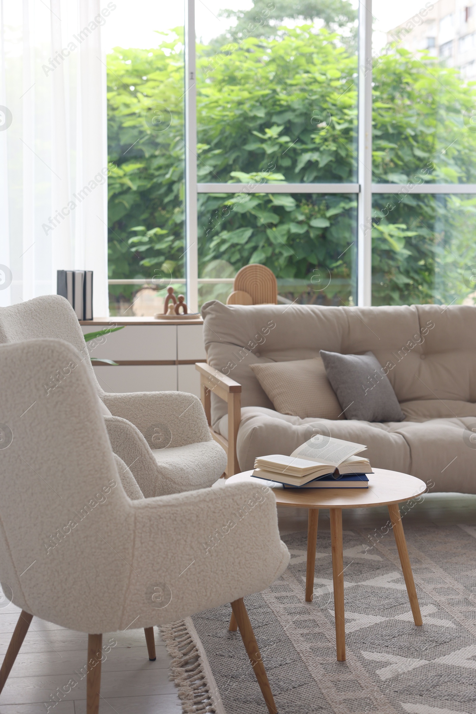 Photo of Stylish sofa and other furniture in living room. Interior design