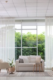 Photo of Stylish sofa and other furniture in living room. Interior design