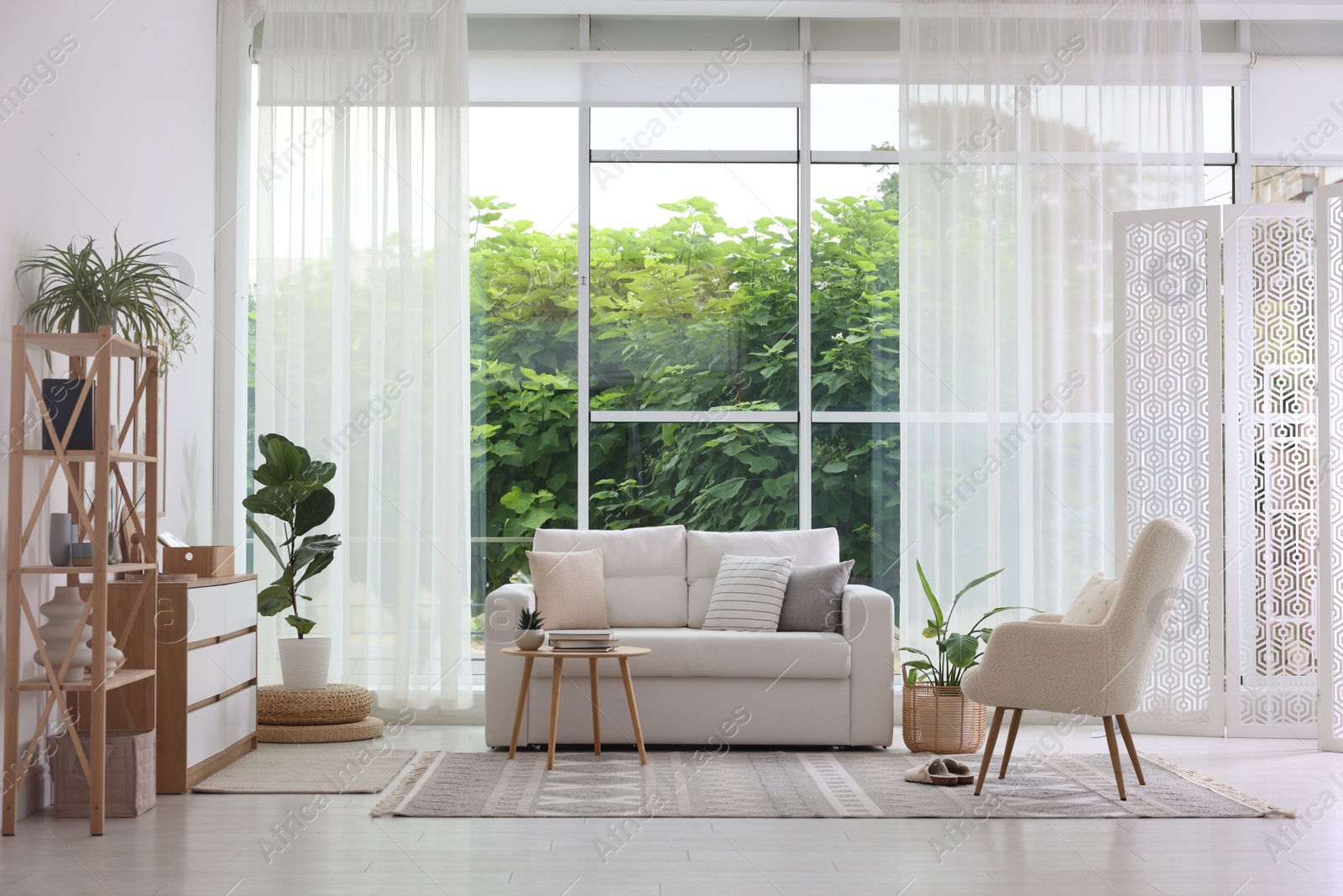 Photo of Stylish sofa and other furniture in living room. Interior design