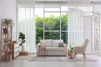 Photo of Stylish sofa and other furniture in living room. Interior design