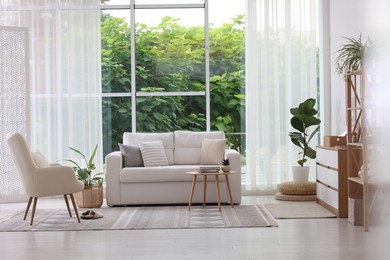 Photo of Stylish sofa and other furniture in living room. Interior design