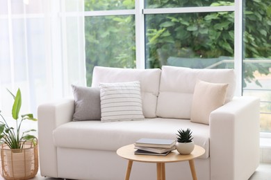 Photo of Stylish sofa and other furniture in living room. Interior design