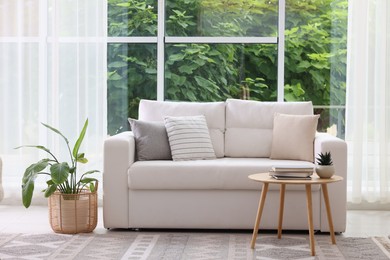 Photo of Stylish sofa and other furniture in living room. Interior design