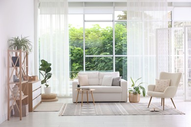 Photo of Stylish sofa and other furniture in living room. Interior design