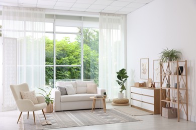 Photo of Stylish sofa and other furniture in living room. Interior design