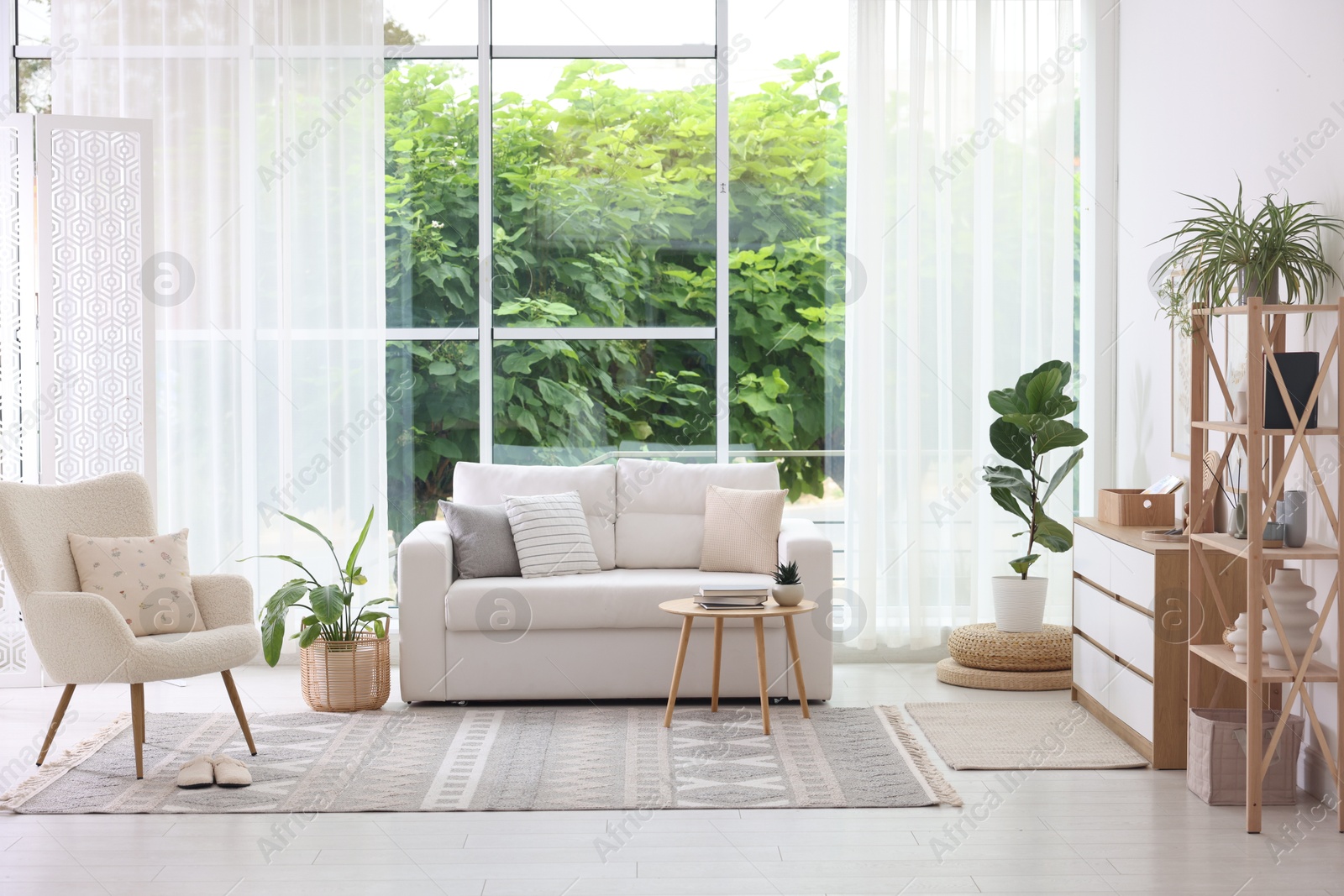 Photo of Stylish sofa and other furniture in living room. Interior design
