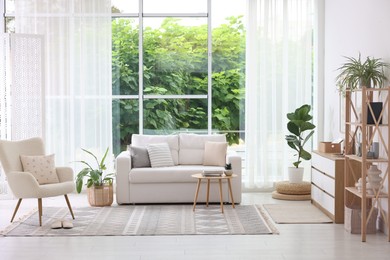Photo of Stylish sofa and other furniture in living room. Interior design