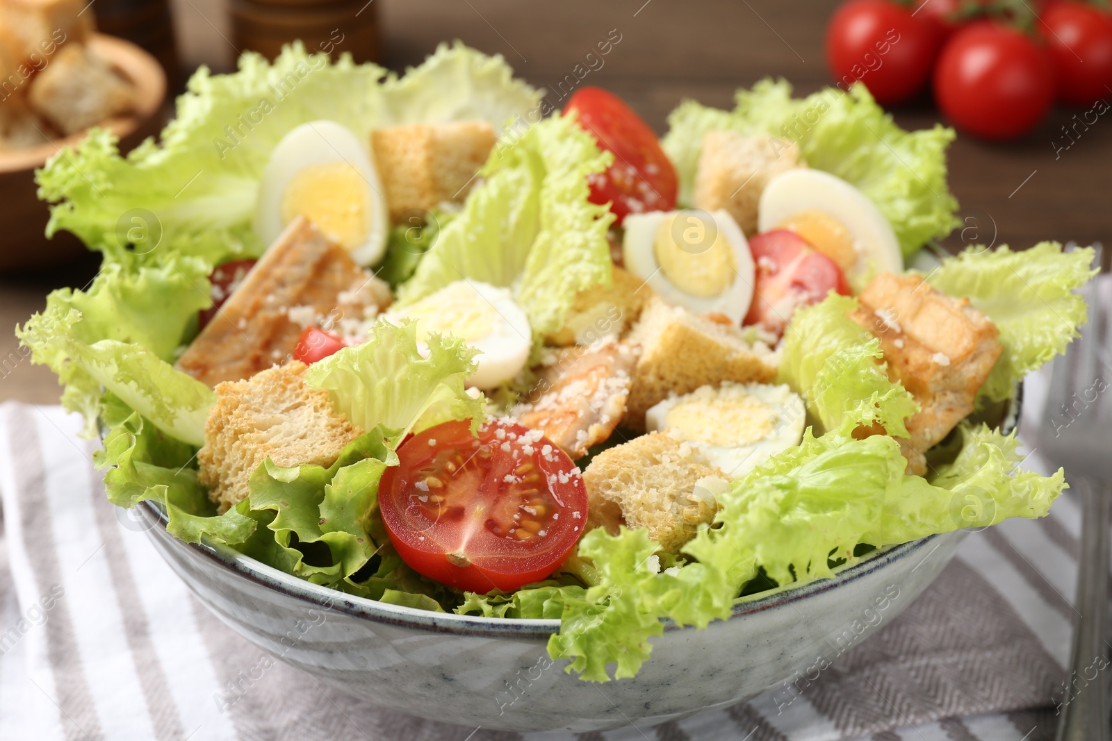 Photo of Delicious salad with croutons, chicken, quail eggs, tomato and cheese on table, closeup