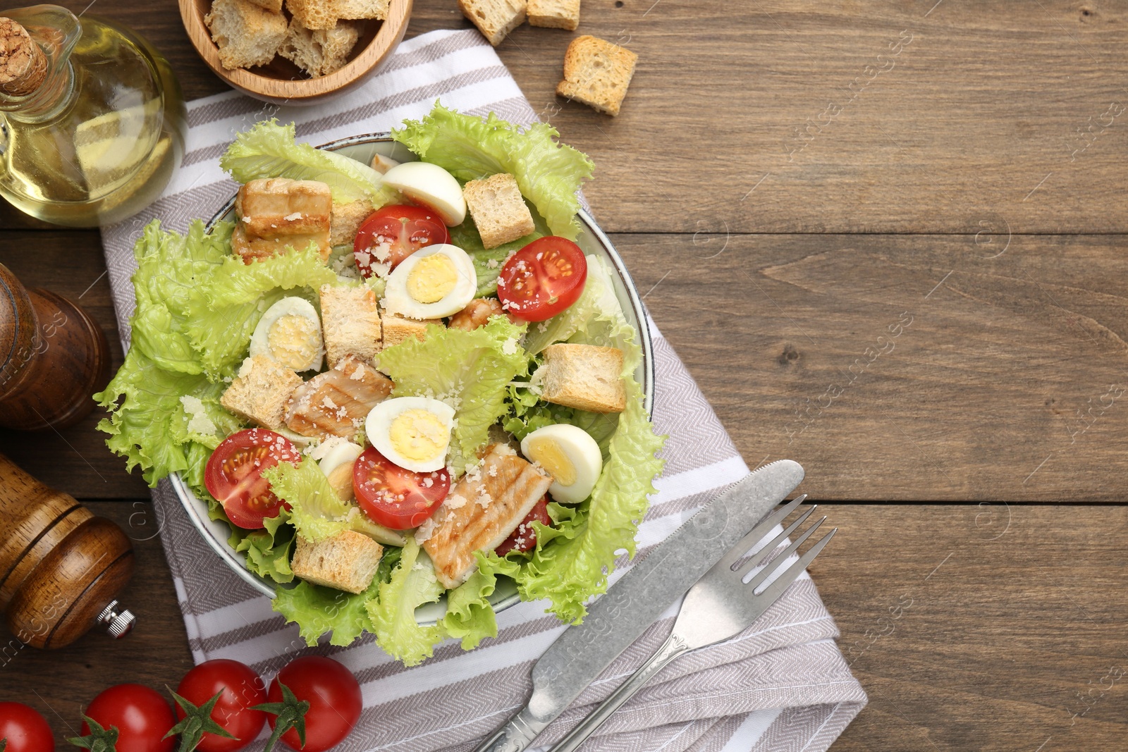 Photo of Delicious salad with croutons and ingredients on wooden table, flat lay. Space for text