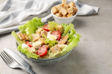 Photo of Delicious salad with croutons, chicken, quail eggs, tomato and cheese on grey table, closeup