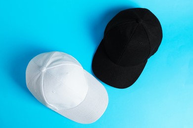 Photo of Baseball hats on light blue background, top view