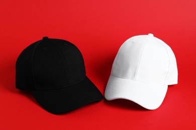 Photo of Black and white baseball hats on red background