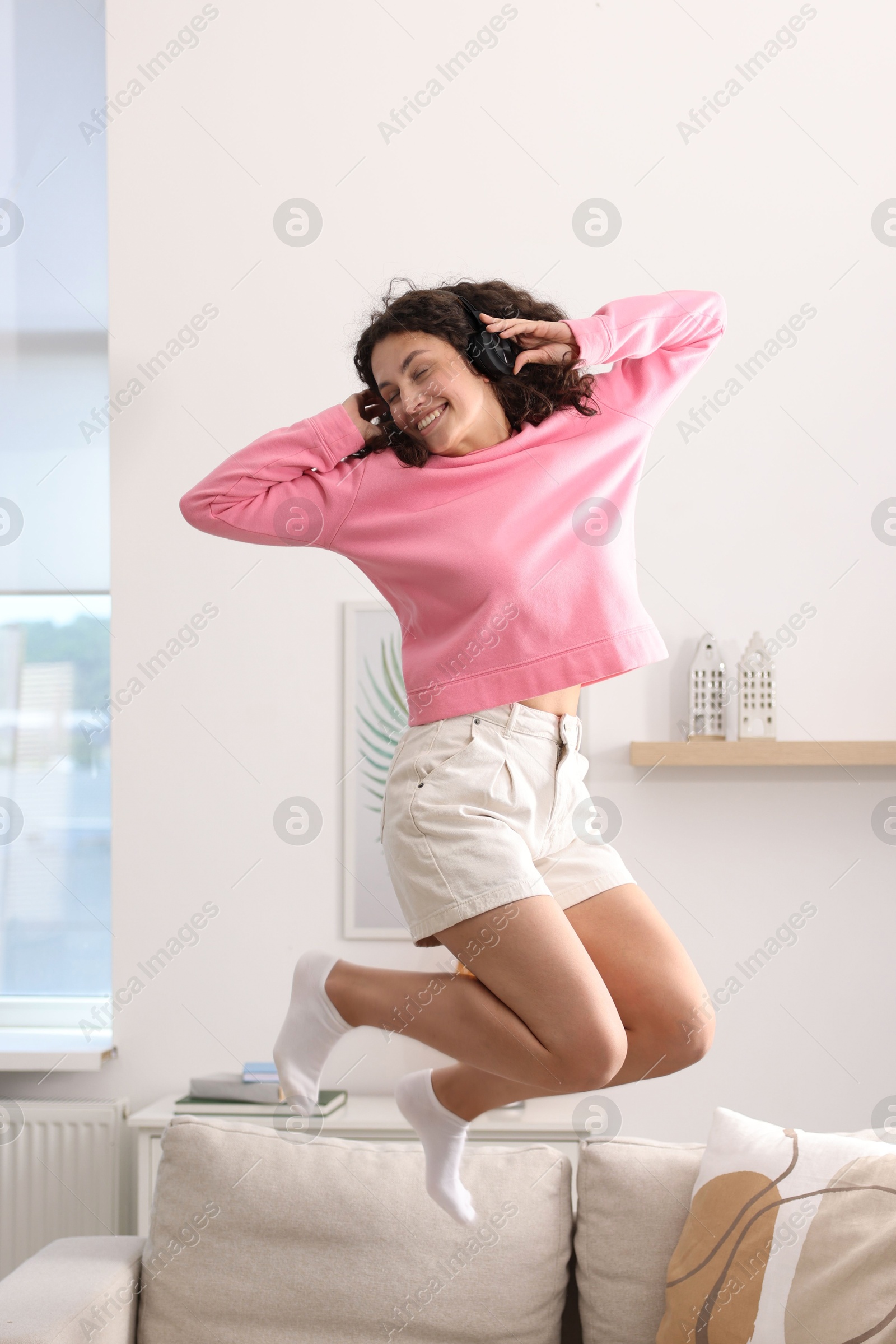 Photo of Young woman with headphones listening to music at home