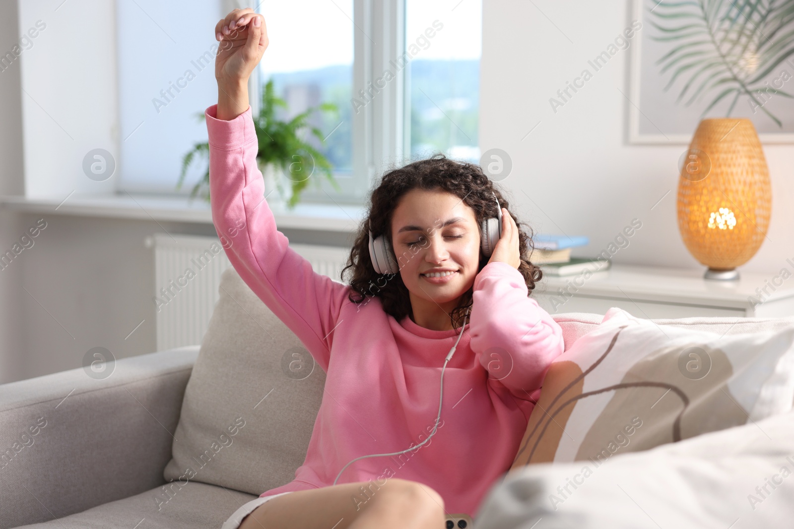 Photo of Young woman with headphones listening to music at home
