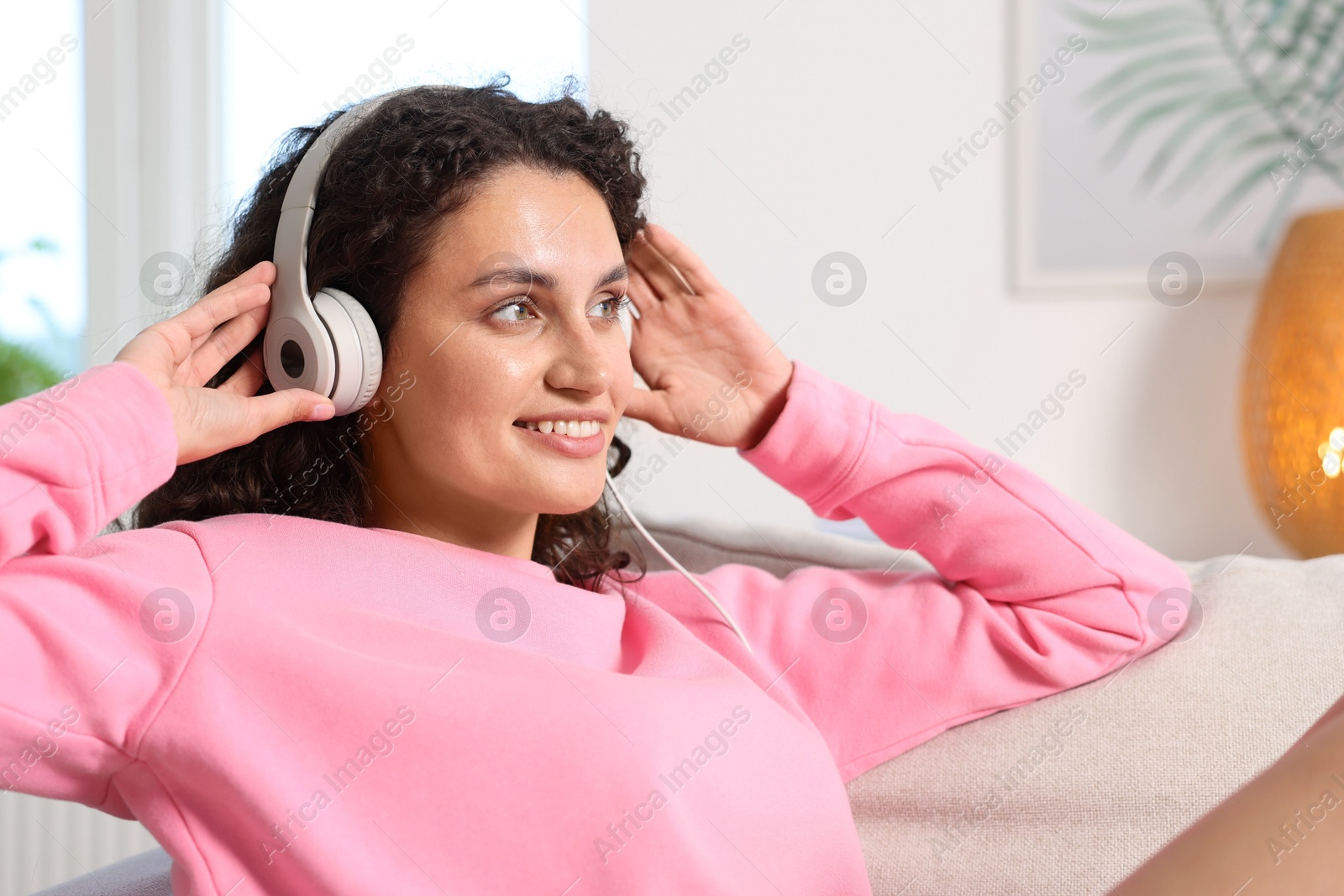 Photo of Young woman with headphones listening to music at home