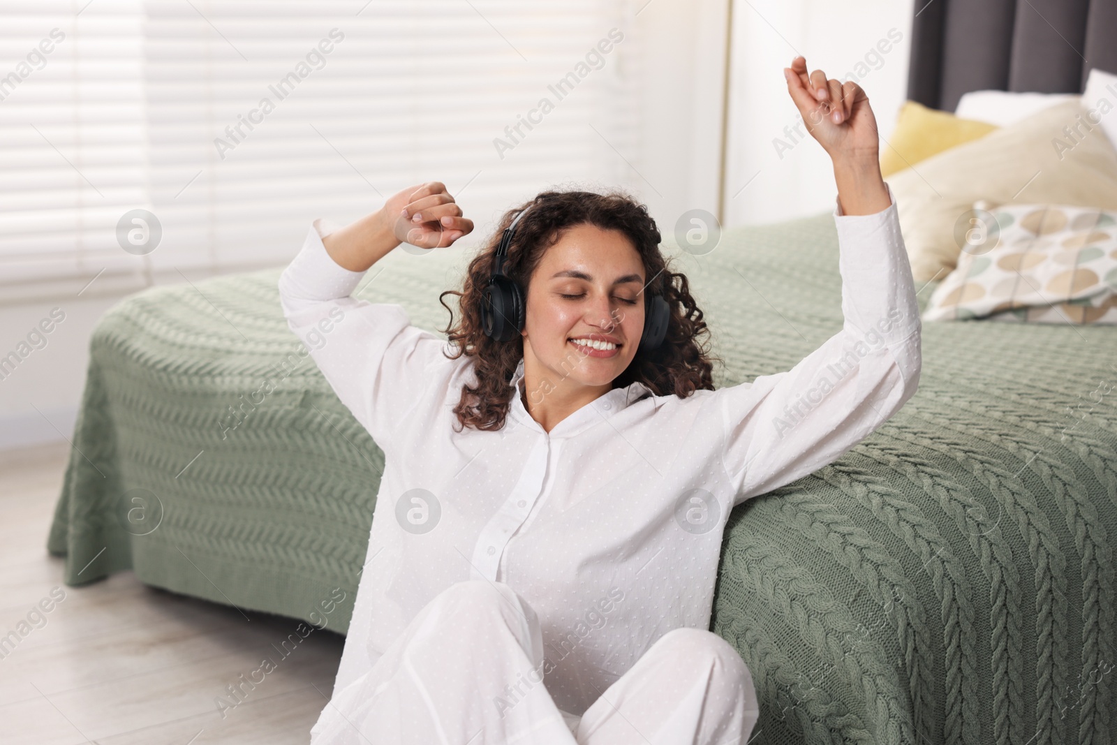 Photo of Young woman with headphones listening to music at home