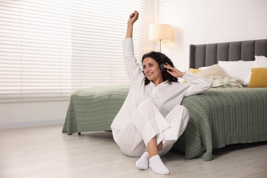 Photo of Young woman with headphones listening to music at home, space for text