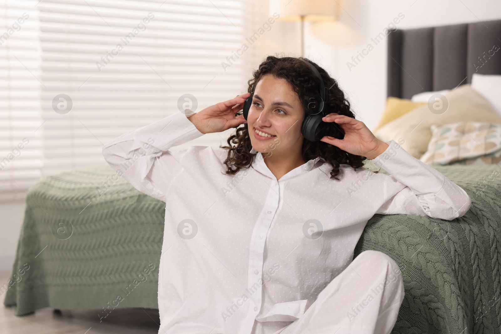 Photo of Young woman with headphones listening to music at home