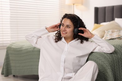 Photo of Young woman with headphones listening to music at home