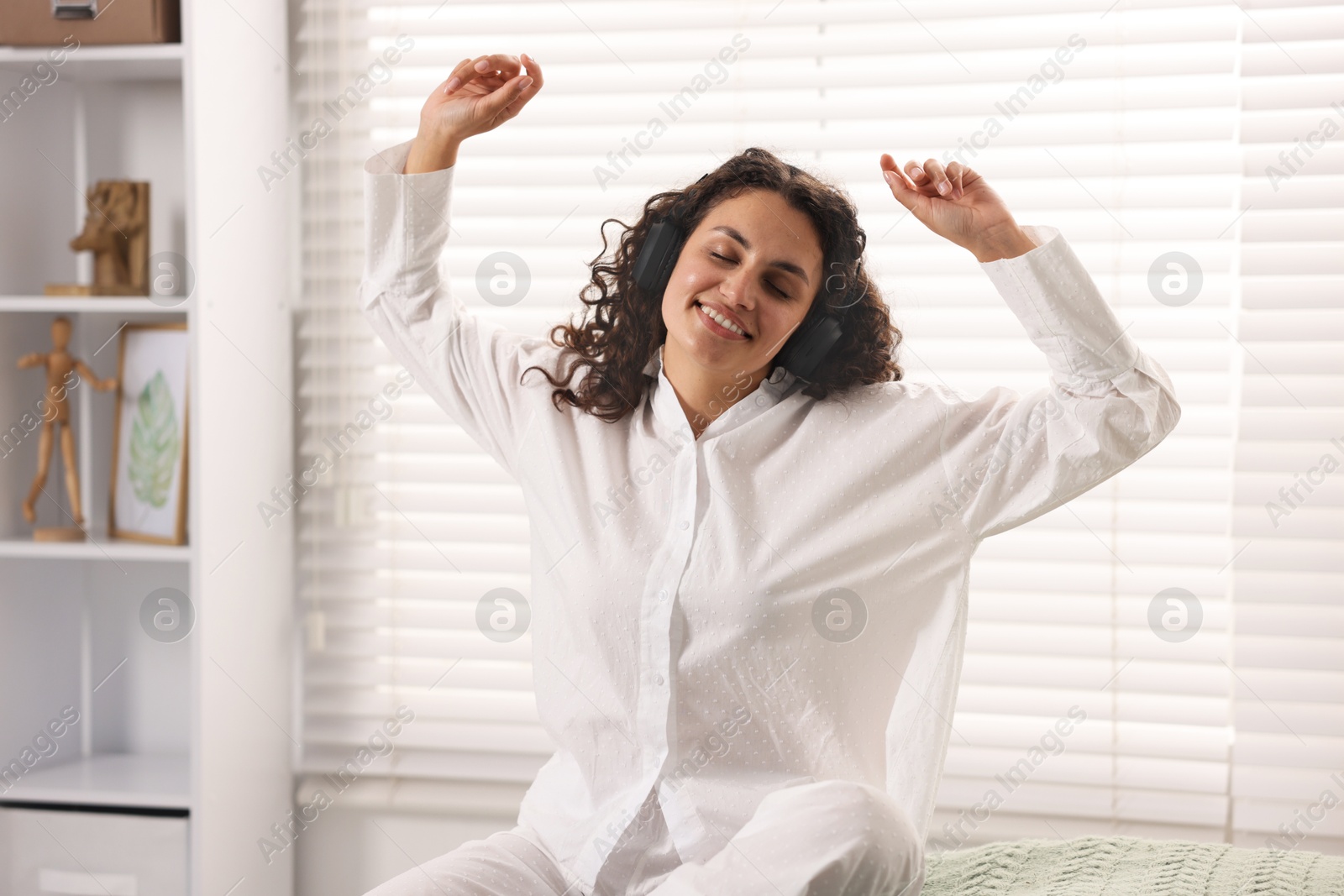 Photo of Young woman with headphones listening to music at home