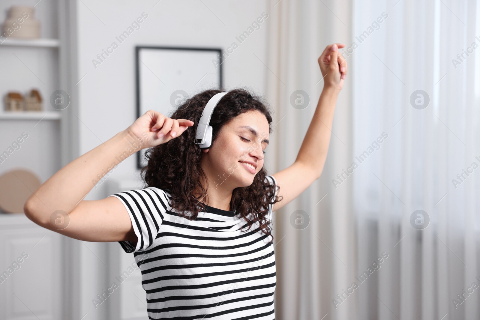 Photo of Young woman with headphones listening to music at home