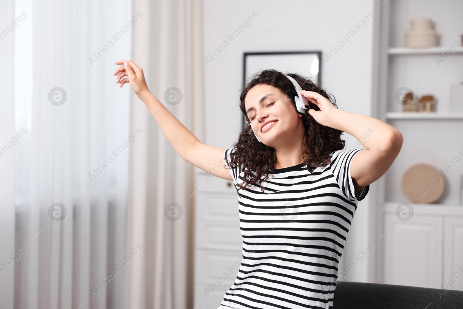 Photo of Young woman with headphones listening to music at home