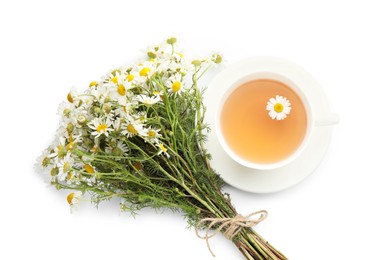 Photo of Aromatic tea in cup and chamomile flowers isolated on white, top view