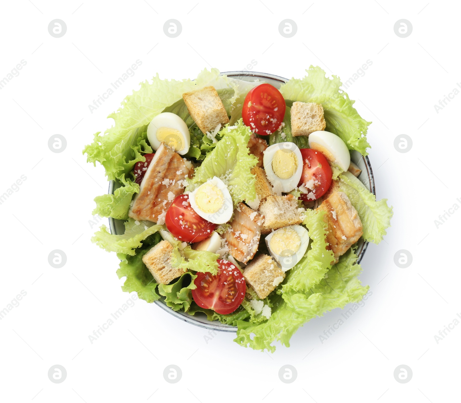 Photo of Delicious salad with croutons, chicken, quail eggs, tomato and cheese in bowl isolated on white, top view