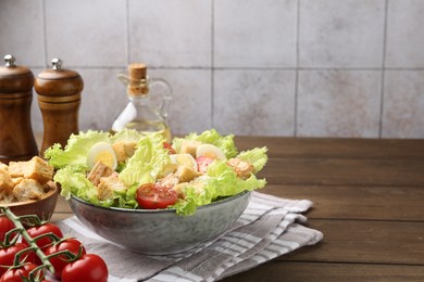 Photo of Delicious salad with croutons and ingredients on wooden table, closeup. Space for text