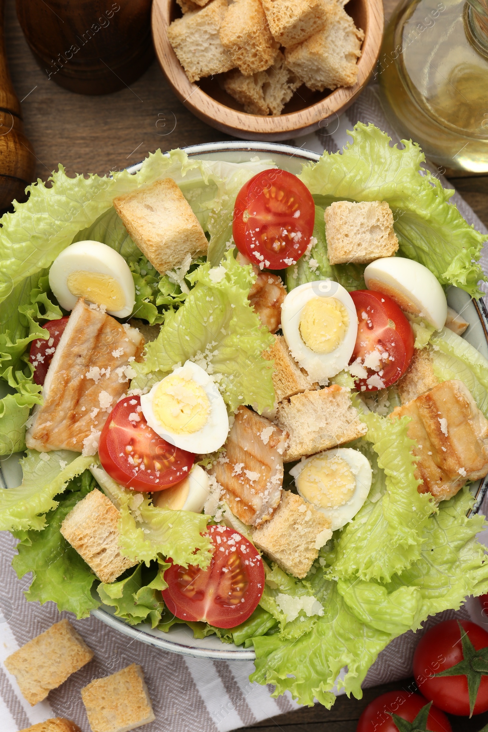 Photo of Delicious salad with croutons and ingredients on table, flat lay