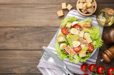 Photo of Delicious salad with croutons and ingredients on wooden table, flat lay. Space for text