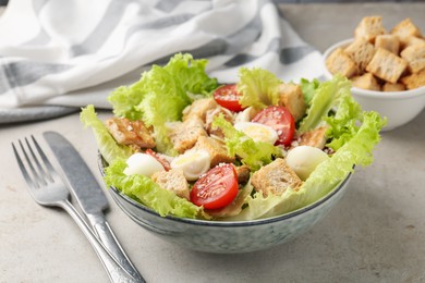 Photo of Delicious salad with croutons, chicken, quail eggs, tomato and cheese on grey table, closeup