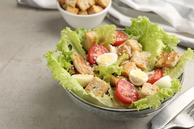 Photo of Delicious salad with croutons, chicken, quail eggs, tomato and cheese on grey table, closeup