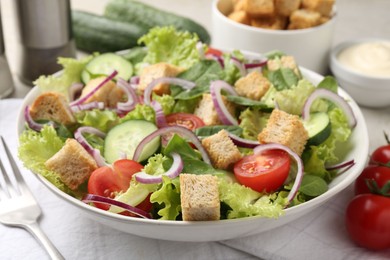 Photo of Delicious salad with croutons and vegetables served on table, closeup