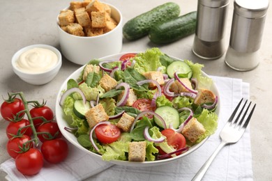 Photo of Delicious salad with croutons and vegetables served on light grey table, closeup