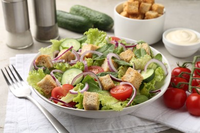 Photo of Delicious salad with croutons and vegetables served on light grey table, closeup